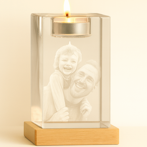 Stiklinė žvakidė su degančia arbatine žvake šalia kristalinio bloko